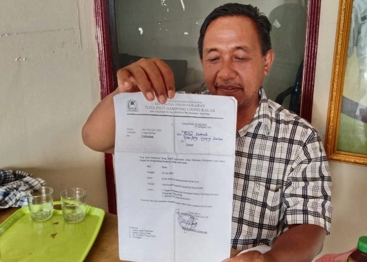 Tata Irfan memegang Surat Undangan yang ditandatangani oleh  Calon Ketua Peut Ujong Kalak, Kecamatan Johan Pahlawan, Aceh Barat yang belum sah Rabu (27/7/2022)