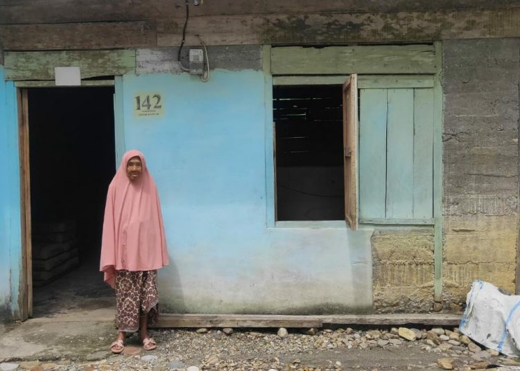 Tampak Nenek Saumi berdiri depan rumah yang tidak layak huni di Desa Suka Damai, Kecamatan Manggeng, Aceh Barat Daya Senin (1/8/2022)