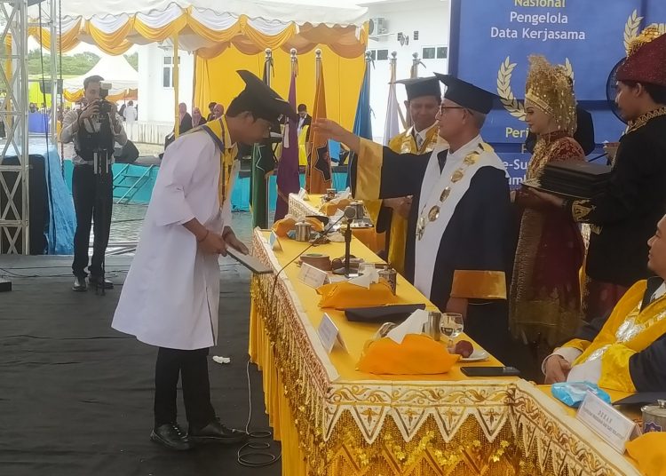 Salah seorang Wisudawan asal Simeulue ROvki Muhammad Akbar S. AN Saat Menerima Ijazah Di UTU, Kabupaten Aceh Barat Sabtu (6/8/2022) foto/Dani