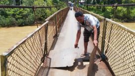 Salah satu warga Kecamatan Kaway XVI, Aceh Barat memperlihatkan alas jembatan yang sudah jebol Kamis ( 25/4/2024) foto/ Dani