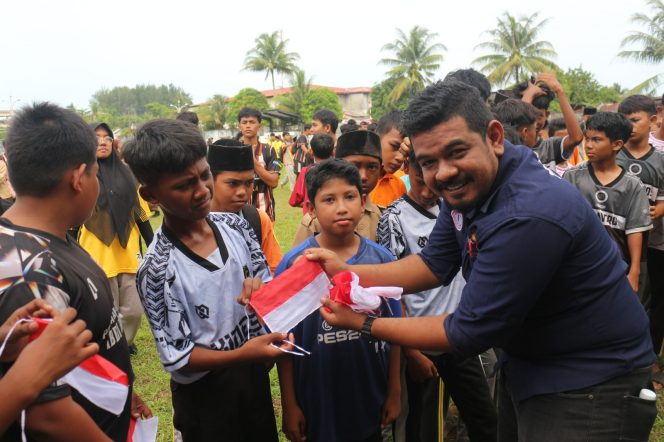 
					Ketua DPD SWI Aceh Barat T.Fadil bagikan Bendera Merah Putih kepada pelajar Jumat (15/8/2025) foto/ dani