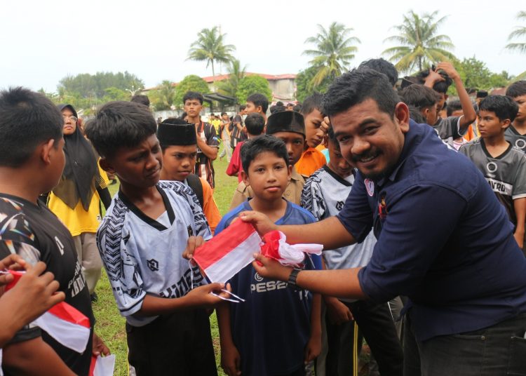 Ketua DPD SWI Aceh Barat T.Fadil bagikan Bendera Merah Putih kepada pelajar Jumat (15/8/2025) foto/ dani