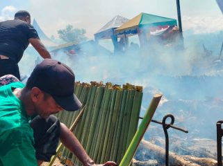 Salah seorang peserta sedang mengatur lemang agar pengapian merata di lokasi bantaran sungai Krueng Beukah, Gampong Lhing Asan, Blangpidie, Sabtu, 25 April 2026.